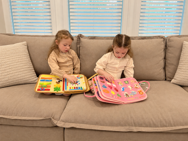 A calm toddler finishing a task on the busy board